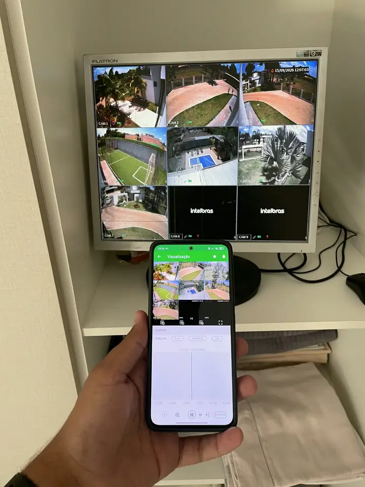 Monitor com 9 câmeras de uma residência e celular mostrando as mesmas imagens no aplicativo