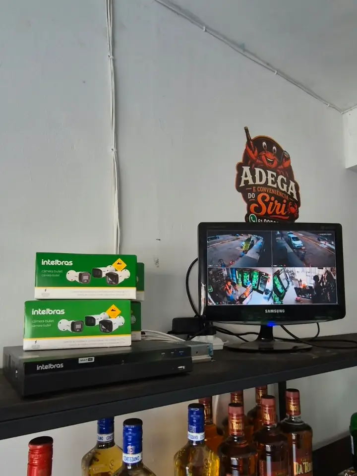 Gravador Intelbras e monitor com câmeras instalados em uma adega