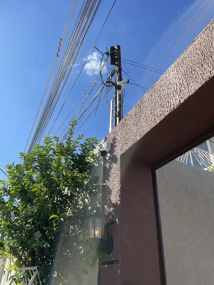 Câmeras externas instaladas no muro e no poste de uma residência
